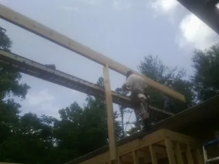 Carpenter setting a ridge beam over a new addition frame — Ice Dam Removal by Roofing Brothers in Spring Grove